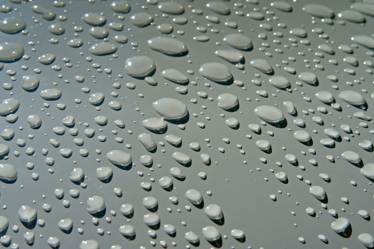 Gocce d'acqua che formano perle perfette sulla carrozzeria trattata con nanotecnologia, effetto idrorepellente
