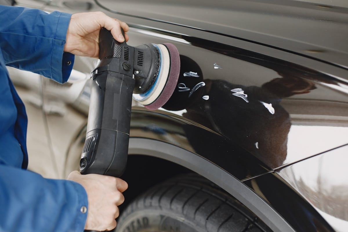 Persona che prepara la superficie dell'auto prima del trattamento nanotecnologico